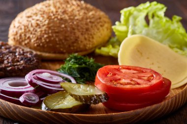 Lezzetli hamburger malzemeler sanatsal organize ahşap plaka, yakın çekim, en iyi görünüm, seçici odak