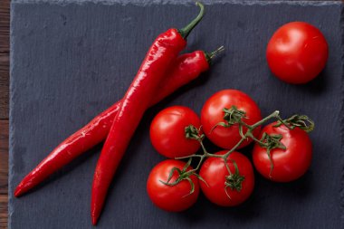 Domates grup ve acı biber siyah parça masa, üstten görünüm, yakın çekim.