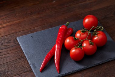 Domates grup ve acı biber siyah parça masa, üstten görünüm, yakın çekim.