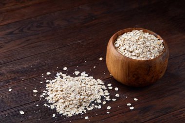 Kase ve izole ahşap arka plan, yakın çekim, üstten görünüm, seçici odak tahta kaşık yulaf gevreği.