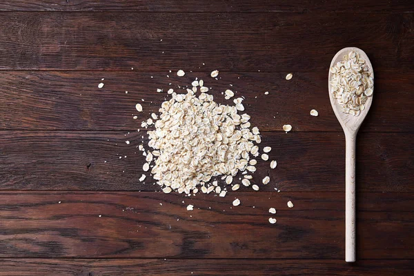 Tahta kaşık ve yulaf vintage ahşap arka plan üzerinde yığın kopyalama alanı, üstten görünüm, yakın çekim, seçici odak