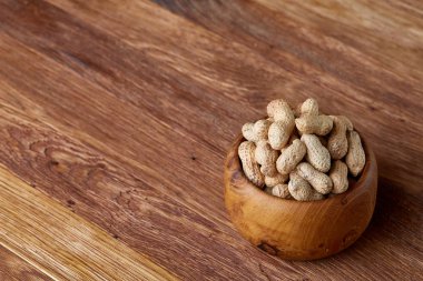 Ahşap kase rustik ahşap arka plan closeup, seçici odak içinde soyulmamış fıstık