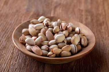 Ahşap arka plan, üstten görünüm, yakın çekim, seçici odak ahşap bir tabakta tuzlu fıstık.