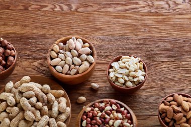 Bir kompozisyon farklı rustik arka plan, yakın çekim, sığ derinlik-in tarla ahşap bir kase içinde fındık çeşitleri