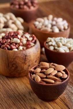 Bir kompozisyon farklı rustik arka plan, yakın çekim, sığ derinlik-in tarla ahşap bir kase içinde fındık çeşitleri