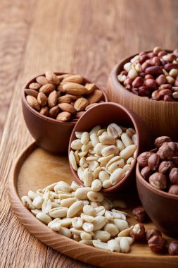 Rustik arka plan, yakın çekim, en iyi görünüm, seçici odak ahşap tepsi üzerinde kahverengi kase karışık Kuruyemiş.