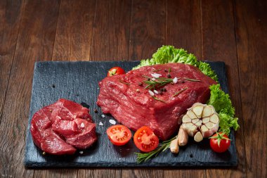 Sebze ile kayrak yönetim kurulu ve baharat, seçici odak, yakın çekim çiğ biftek bileşimi.