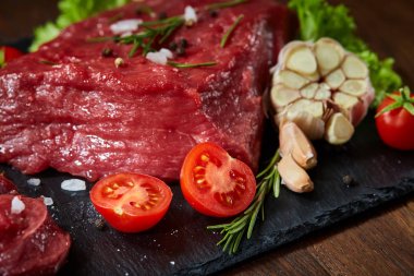 Sebze ile kayrak yönetim kurulu ve baharat, seçici odak, yakın çekim çiğ biftek bileşimi.