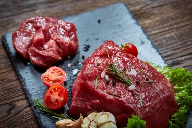 Sebze ile kayrak yönetim kurulu ve baharat, seçici odak, yakın çekim çiğ biftek bileşimi.