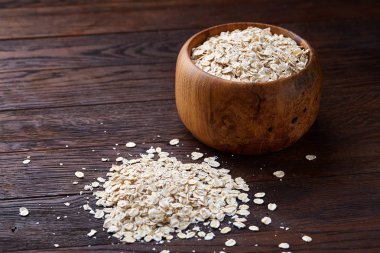 Kase ve izole ahşap arka plan, yakın çekim, üstten görünüm, seçici odak tahta kaşık yulaf gevreği.