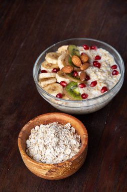 Meyve, kase ve kaşık yulaf gevreği, seçici odak, yakın çekim ile diyet kahvaltı yulaf ezmesi