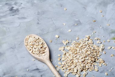 Tahta kaşık ve yulaf beyaz dokulu arka planda, yığın kopyalama alanı, üstten görünüm, yakın çekim, seçici odak