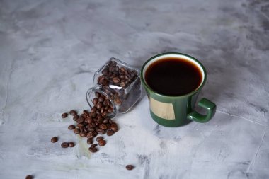 Kahve fincanı, kahve çekirdekleri, ahşap arka plan, seçici odak, yakın çekim taş tahta üzerinde çikolata şekerleme