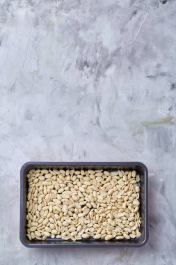 Tepsi üzerinde beyaz ekmek üzerinde soyulmuş fıstık dokulu arka plan, seçici odak, sığ derinlik-in tarla.