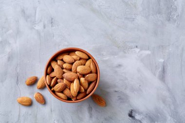 Badem beyaz kase dokulu arka plan, üstten görünüm, yakın çekim, seçici odak.