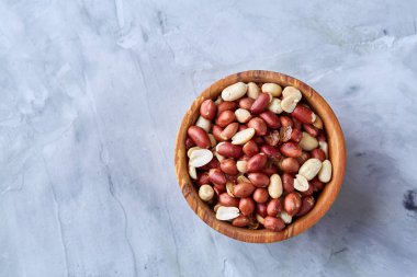 Ahşap plaka izole beyaz dokulu arka plan, üstten görünüm, yakın çekim üzerinde ham karışık fıstık.