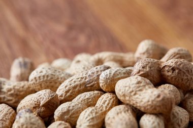 Ahşap arka plan, üstten görünüm, seçici odak, sığ derinlik-in tarla soyulmamış fıstık.