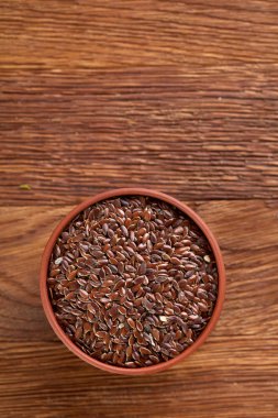Ahşap arka plan, üstten görünüm, yakın çekim bir tabak içinde keten tohumu.