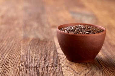 Ahşap arka plan, üstten görünüm, yakın çekim bir tabak içinde keten tohumu.