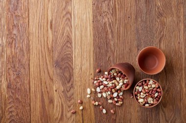 İzole rustik ahşap artalanları, üstten görünüm, yakın çekim üzerinde çiğ fıstık karışımı ile iki seramik kase.