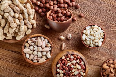 Bir kompozisyon farklı rustik arka plan, yakın çekim, sığ derinlik-in tarla ahşap bir kase içinde fındık çeşitleri