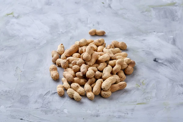 Seamless pattern shelled peanuts isolated on white background, top view, close-up, selective focus