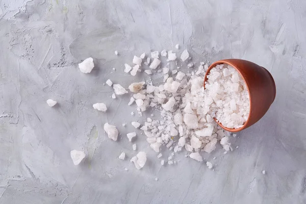 Composición de sal marina en cuenco de cerámica y cuchara para cocinar o spa sobre fondo blanco, vista superior, enfoque selectivo — Foto de Stock