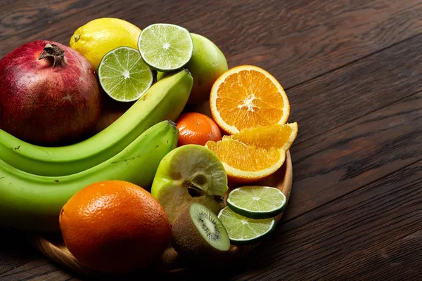 Mogna frukter i en träplatta på en ljus trä bakgrund, selektivt fokus, närbild, top view — Stockfoto