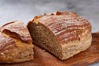 Taze çavdar ekmeği somun bir Ahşap doğrama üzerinde kurulu beyaz dokulu arka plan sığ derinlik-in tarla