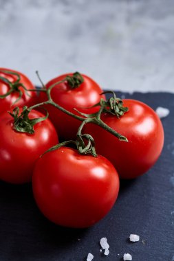 Demet taze domates yeşil taşlı tahtada yaprakları beyaz arka plan, üstten görünüm, yakın çekim, seçici odak üzerinde