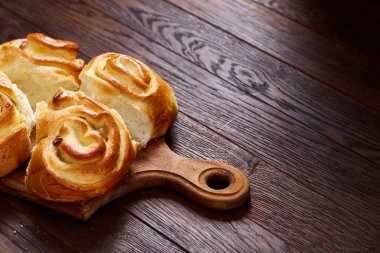 Ev yapımı gül buns üzerinde ahşap kesme tahtası rustik antika arka plan, yakın çekim, sığ derinlik-in tarla