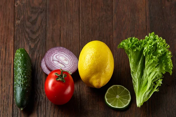 Fresh vegetables still life. Veges lined up on a wooden background, top view, close-up, selective focus, copy space.