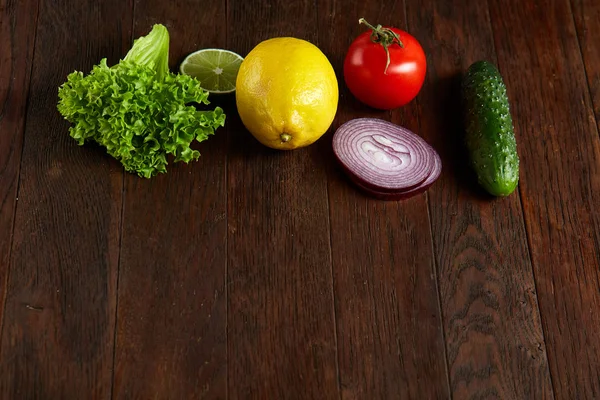 Fresh vegetables still life. Veges lined up on a wooden background, top view, close-up, selective focus, copy space.