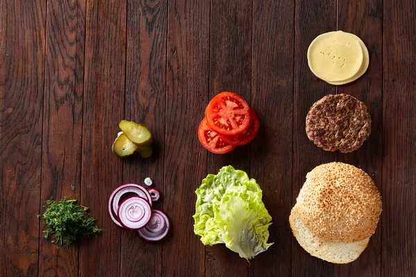 Tasty hamburger ingredients are laid out separately from above, beautifully harmoniously, close-up, top view