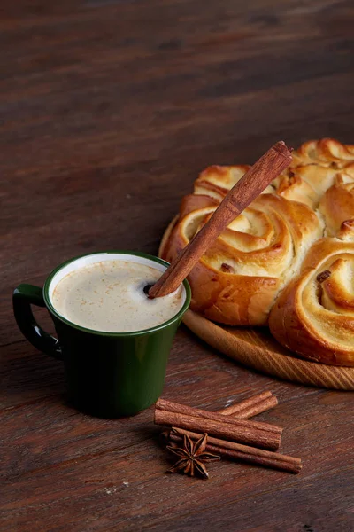 Homemade rose bread, cup of coffee, anise and cinnamon on vintage background, close-up, selective focus