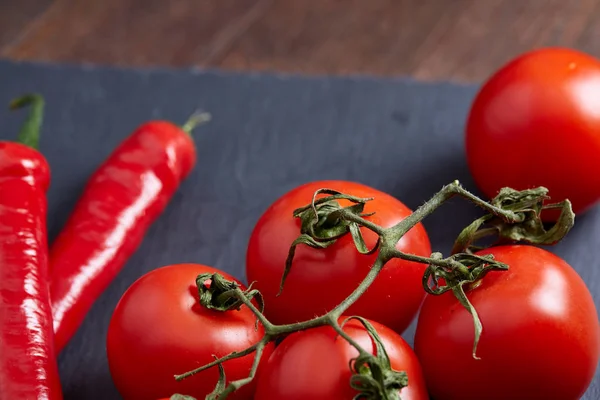 Bodegón vegetariano con tomates frescos de uva, pimienta y sal en cuchara de madera sobre fondo de madera, enfoque selectivo — Foto de Stock