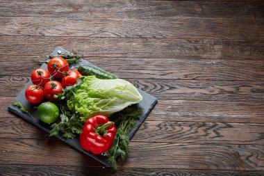 Çeşitli taze sebze ve otlar rustik ahşap arka plan, üstten görünüm, seçici odak sanatsal natürmort.