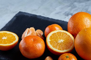 Taze mandalina ve turuncu masa, yakın çekim kesme üzerinde tam ve yarım kesilmiş