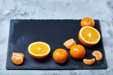 Taze mandalina ve turuncu masa, yakın çekim kesme üzerinde tam ve yarım kesilmiş