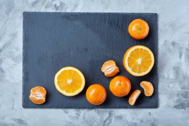 Taze mandalina ve turuncu masa, yakın çekim kesme üzerinde tam ve yarım kesilmiş