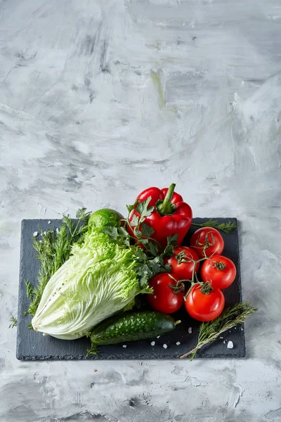 Deliciosa composición de una variedad de verduras frescas y hierbas sobre fondo de textura blanca, vista superior, enfoque selectivo . — Foto de Stock