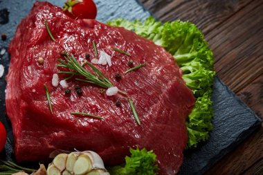 Sebze ile kayrak yönetim kurulu ve baharat, seçici odak, yakın çekim çiğ biftek bileşimi.