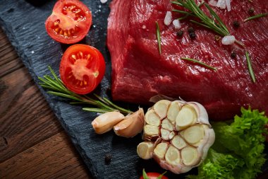 Sebze ile kayrak yönetim kurulu ve baharat, seçici odak, yakın çekim çiğ biftek bileşimi.