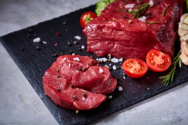 Sebze ile kayrak yönetim kurulu ve baharat, seçici odak, yakın çekim çiğ biftek bileşimi.