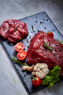 Sebze ile kayrak yönetim kurulu ve baharat, seçici odak, yakın çekim çiğ biftek bileşimi.