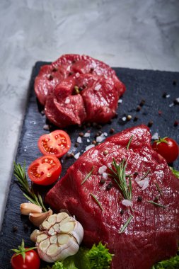 Sebze ile kayrak yönetim kurulu ve baharat, seçici odak, yakın çekim çiğ biftek bileşimi.