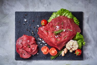 Sebze ile kayrak yönetim kurulu ve baharat, seçici odak, yakın çekim çiğ biftek bileşimi.