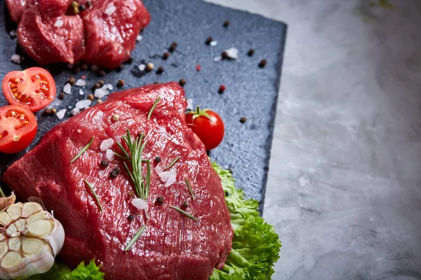 Sebze ile kayrak yönetim kurulu ve baharat, seçici odak, yakın çekim çiğ biftek bileşimi.