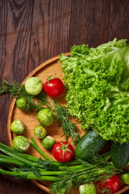 Rustik arka plan, yakın çekim, düz ahşap plaka üzerinde taze sebze vejetaryen natürmort yatıyordu.