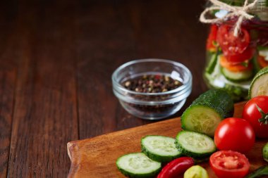 Kavanoz ve tablo, seçici odak, yakın çekim kesme tahtası üzerinde taze sebzeler lezzetli sebze salatası